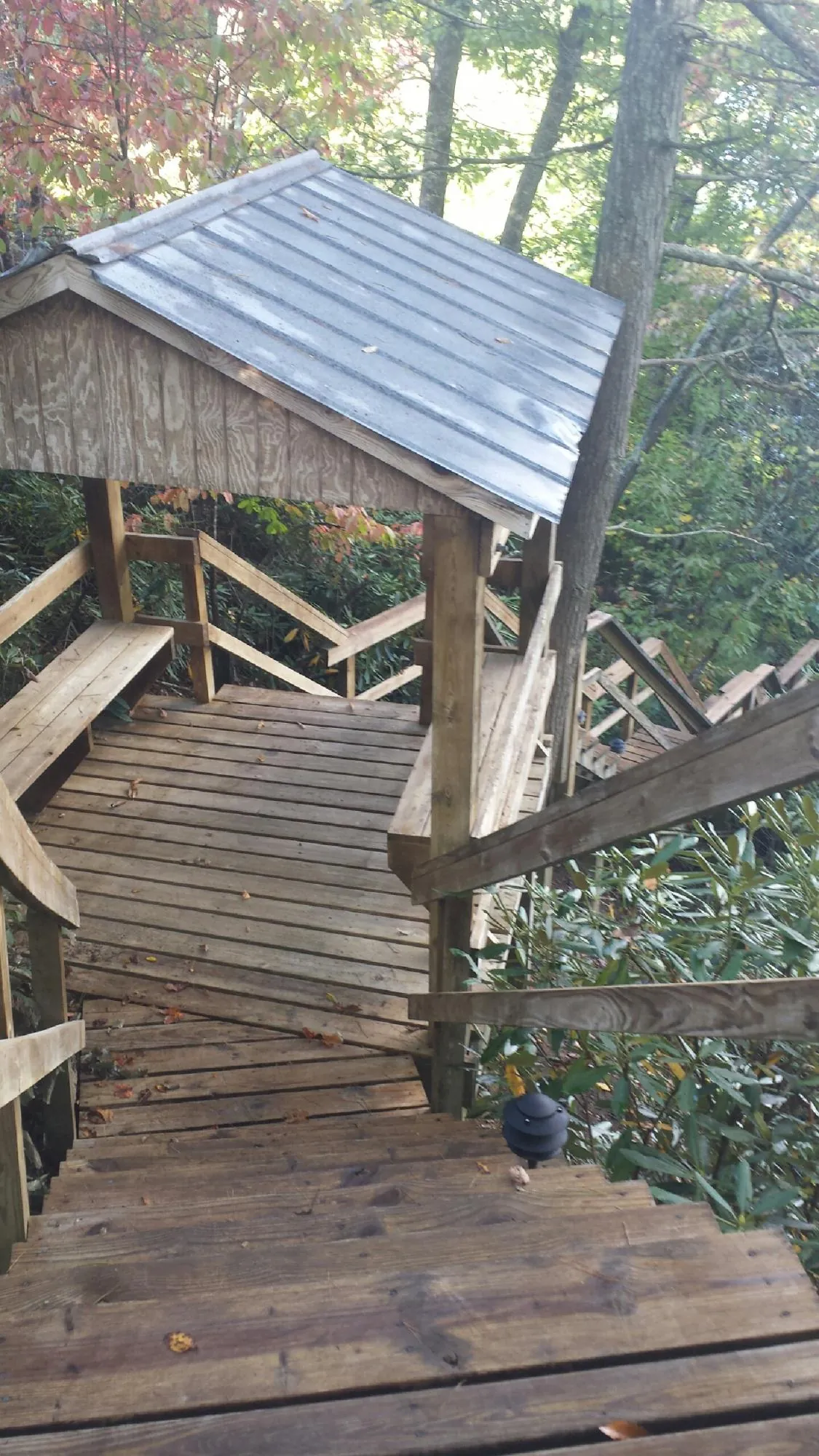 Metal roofed shelter over wooden steps on a wooded walkway — Skylight Repair & Installation work by our crew in State Road