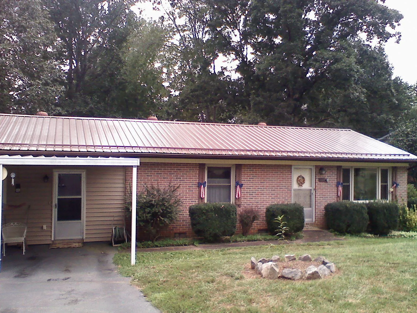 Bronze metal roof and carport on a brick ranch home — Roof Repair work by our crew in State Road